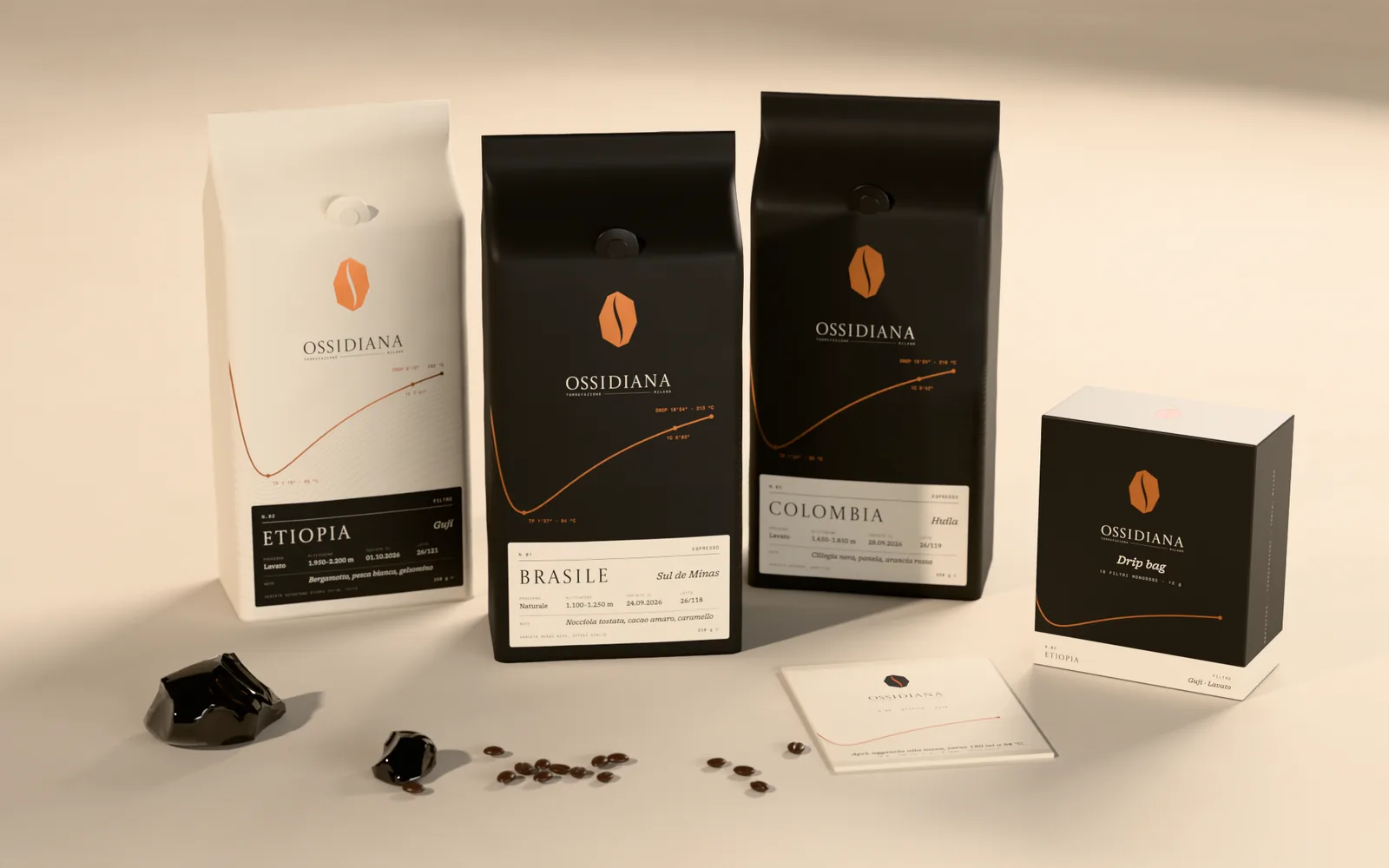 Linea di sacchetti da 250 g: Etiopia in color pomice per il filtro, Brasile e Colombia neri per l’espresso, ciascuno con la propria curva di tostatura e un’etichetta con origine, processo, altitudine, data di tostatura e note; a destra la scatola da dieci drip bag e una bustina monodose.